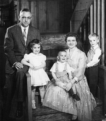 Family photo of Clark and Wanda Bass with their children, smiling in staircase of family home.