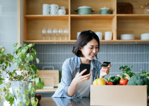 Woman using phone and debit card