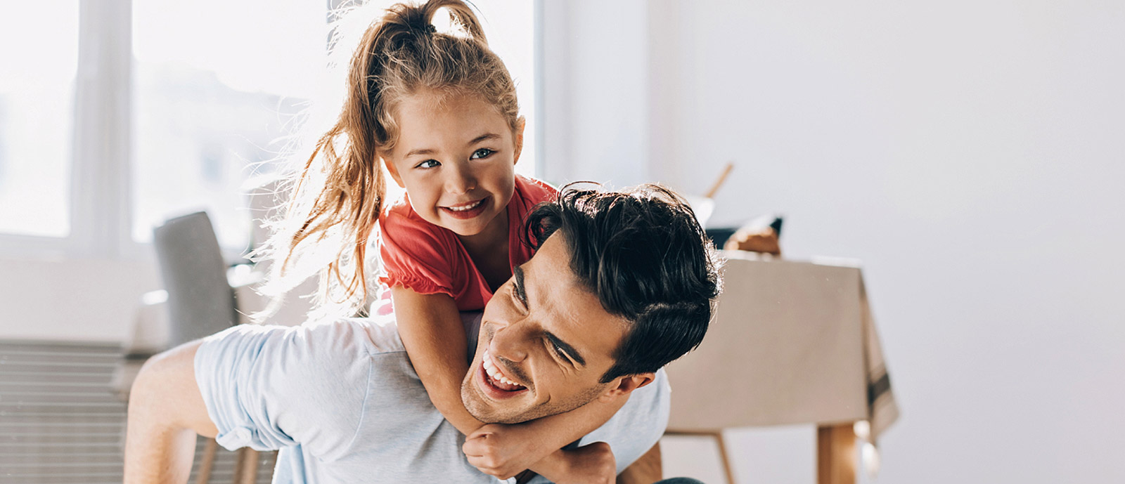 Man playing with daughter in living room