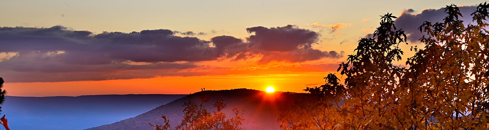 Sun setting behind a mountain