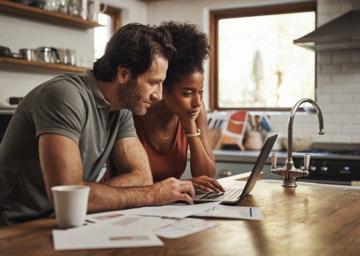 Young couple using laptop in kitchen