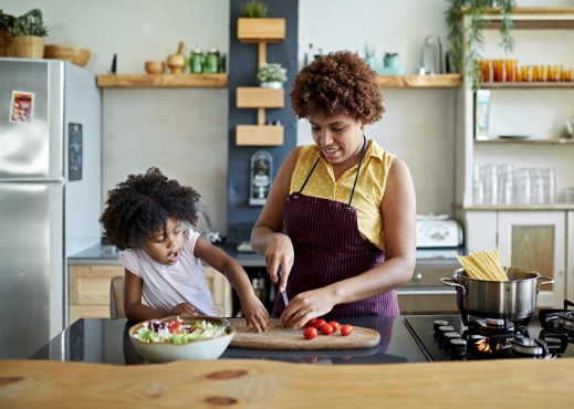 Mother and daughter preparing a meal in kitchen