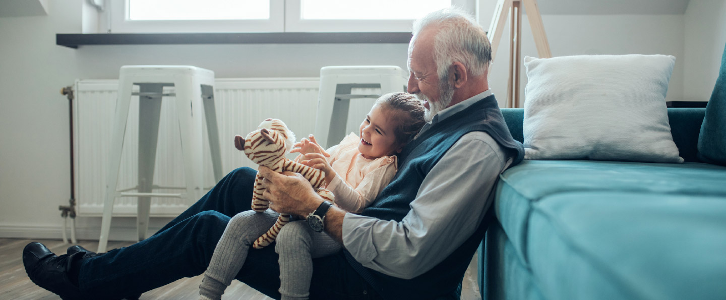 Man playing with granddaughter in living room